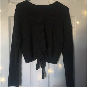 Gray sweater with lace up design on back.